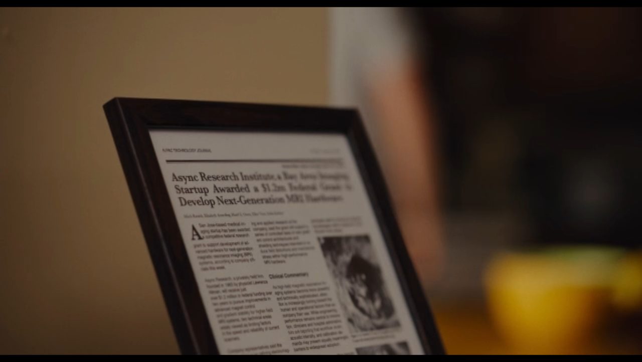 A framed newspaper clipping: Async Research Institute awarded an MRI grant